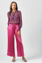 Load image into Gallery viewer, Woman wearing a patterned top and pink pants on a white background