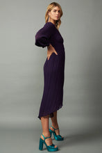 Load image into Gallery viewer, Pleated V-neck midi dress with ruffle trim and an elasticized waist. Subtle high-low hem with front slit and delicate lettuce edge. Adorable tie detail at the back.