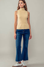 Load image into Gallery viewer, Woman wearing a beige sleeveless sweater and blue jeans against a plain background