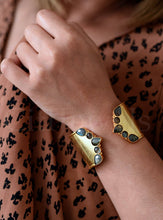 Load image into Gallery viewer, Gold cuff bracelets on a wrist with a leopard print background