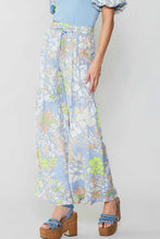 Load image into Gallery viewer, The model looks stylish in a blue top and wide-leg floral print pants, cinched at the waist with a self-tie belt.