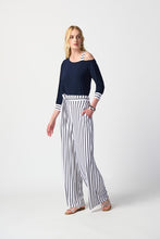 Load image into Gallery viewer, Chic woman donning blue top and striped pants, epitomizing timeless fashion with a touch of flair.