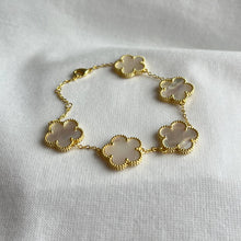 Load image into Gallery viewer, Gold bracelet with white clover-shaped mother of pearl charms.