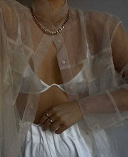 Load image into Gallery viewer, A woman showcases a sheer top and accessorizes with a chunky Cuban chain necklace, which effortlessly enhances her ensemble.