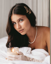 Load image into Gallery viewer, Graceful woman in white dress holds a candle, displaying a stunning pearl necklace with genuine freshwater pearls.