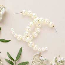 Load image into Gallery viewer, Earrings with pearl beads arranged in an overlapping double-C design on white background. Elegant and sophisticated, conveying luxury and style.