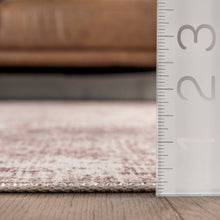 Load image into Gallery viewer, A ruler positioned beside a couch on the floor, showcasing a sleek and sophisticated machine-made rug with flat pile and non-slip backing.