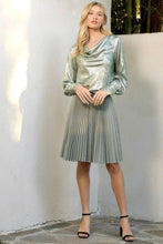 Load image into Gallery viewer, Woman wearing a metallic silver dress standing against a white wall.