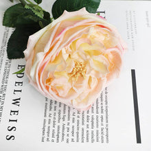 Load image into Gallery viewer, A delicate Real Touch rose resting on a book with a leaf, showcasing the beauty of a real touch rose stem. Perfect for floral designs and wedding bouquets.