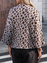 Load image into Gallery viewer, Person wearing a gray cardigan with a leopard print pattern outdoors.
