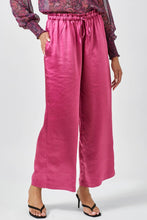 Load image into Gallery viewer, Person wearing pink satin pants with a plain background