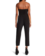 Load image into Gallery viewer, Harlan Strapless Wrap Belt Jumpsuit worn by a woman in black with a stylish bow accent.