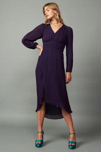 Subtly sheer V-neck midi dress with pleats and ruffle trim. Elasticized waist, high-low hem with front slit, and back tie detail.