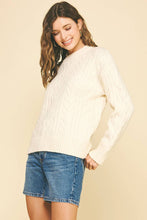 Load image into Gallery viewer, Woman wearing a cream sweater and denim shorts against a beige background
