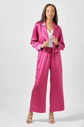 Woman wearing a pink satin outfit on a white background