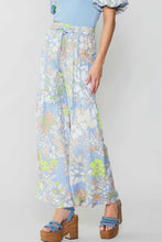 Load image into Gallery viewer, The model looks stylish in a blue top and wide-leg floral print pants, cinched at the waist with a self-tie belt.
