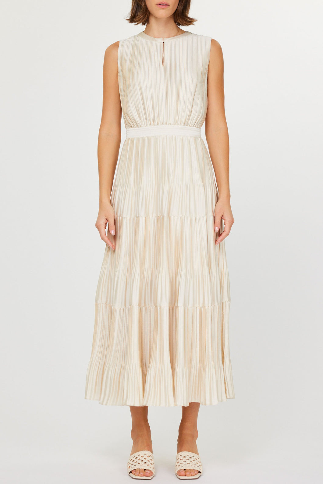 Elegant sleeveless dress with pleats, a keyhole neckline, and a tiered skirt, creating a stunning silhouette.