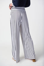 Load image into Gallery viewer, Stylish woman donning striped pants and a black and white striped shirt, epitomizing fashion-forward attire with a touch of class.
