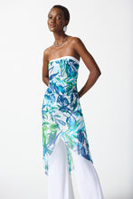 Load image into Gallery viewer, Silky knit strapless jumpsuit with flared leg and sheer high-low overlay in vibrant tropical print exudes feminine chic grace.
