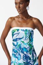 Load image into Gallery viewer, Graceful strapless jumpsuit in silky knit fabric features flared leg, sheer high-low overlay, and vibrant tropical print.
