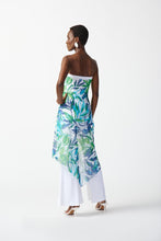 Load image into Gallery viewer, This strapless jumpsuit in silky knit fabric showcases a flared leg, sheer high-low overlay, and vibrant tropical print for a chic look.
