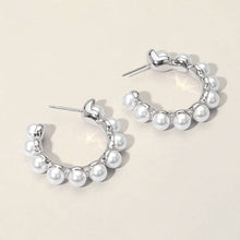Load image into Gallery viewer, Silver hoop earrings with white pearl beads arranged along the hoop. The earrings have a shiny, metallic finish
