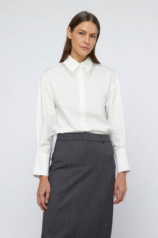 Elevate your style with a white beaded lapel shirt and a sleek grey skirt, perfect for any elegant occasion.