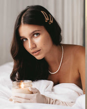 Load image into Gallery viewer, Graceful woman in white dress holds a candle, displaying a stunning pearl necklace with genuine freshwater pearls.
