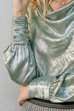 Load image into Gallery viewer, Close-up of a person wearing a metallic green outfit with puffed sleeves against a neutral background

