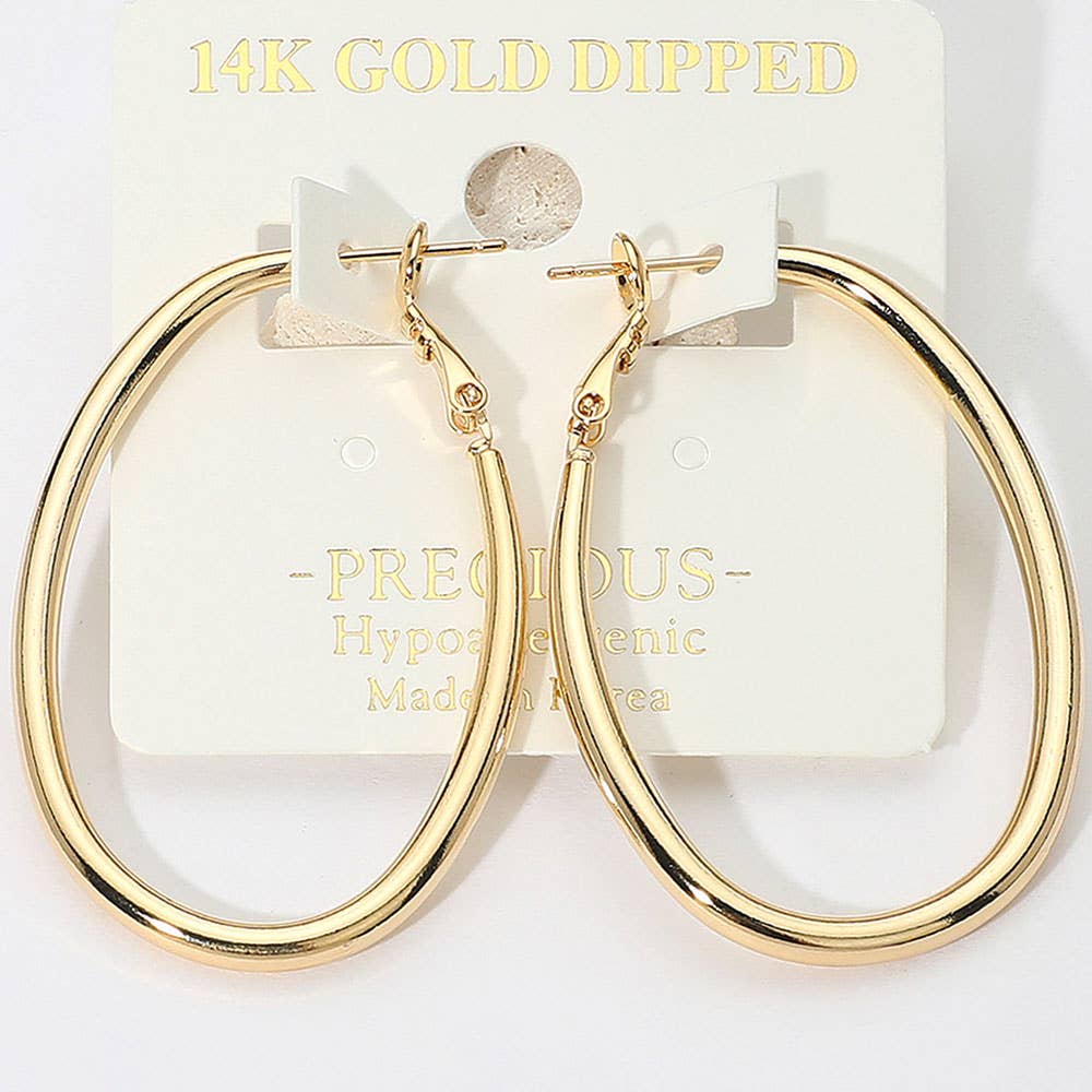 Oval-shaped hoop earrings with a 14K gold-dipped finish hang on a display card labeled 'PRECIOUS, Hypoallergenic, Made in Korea.' The design conveys elegance and simplicity