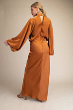 Load image into Gallery viewer, Woman wearing a long orange dress against a beige background
