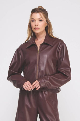 Woman wearing a brown leather jumpsuit on a white background
