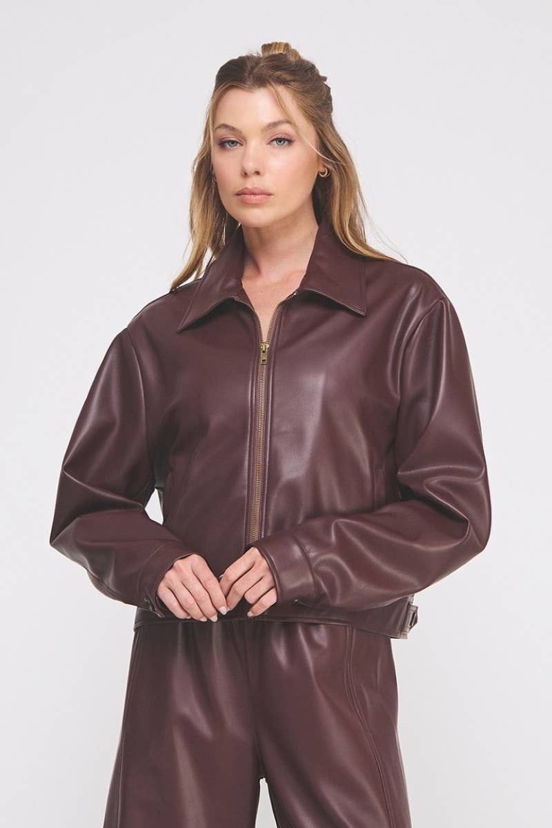 Woman wearing a brown leather jumpsuit on a white background