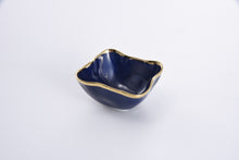 Load image into Gallery viewer, Enjoy snacks in the Sunset By The Sea square bowl, ideal for individual snacking, dips, or toppings. Perfect for taco, sundae, or pizza night! Crafted in luxurious blue glazed high-fired porcelain with vibrant gold-tone rims. Food safe, tarnish free, dishwasher and oven safe to 500°. Easy Care.
