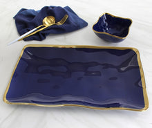 Load image into Gallery viewer, Square snack bowl in Sunset By The Sea. Great for snacking, dips, or toppings. Ideal for a make your own taco, sundae, or pizza night! Perfect addition to any bar for lemons and limes. Crafted in blue glazed porcelain with gold-tone rims. Food safe, dishwasher safe, and oven safe to 500°. Easy to care for.

