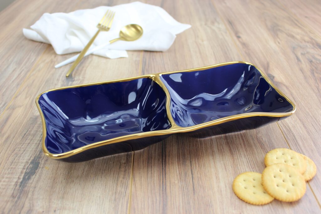 Blue glazed porcelain 2 section server with gold-tone rims. Perfect for appetizers, desserts, and sides. Food safe, dishwasher safe, and oven safe to 500°.