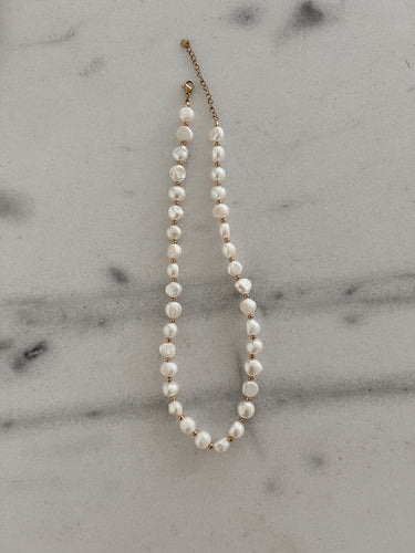 A delicate pearl necklace with small gold chain segments, gold adjustable clasp allows for easy adjustment to desired length.