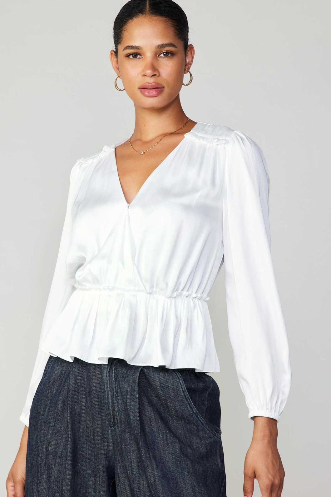 Elevate your style with this white V-neck blouse featuring beautiful ruffles and long sleeves.