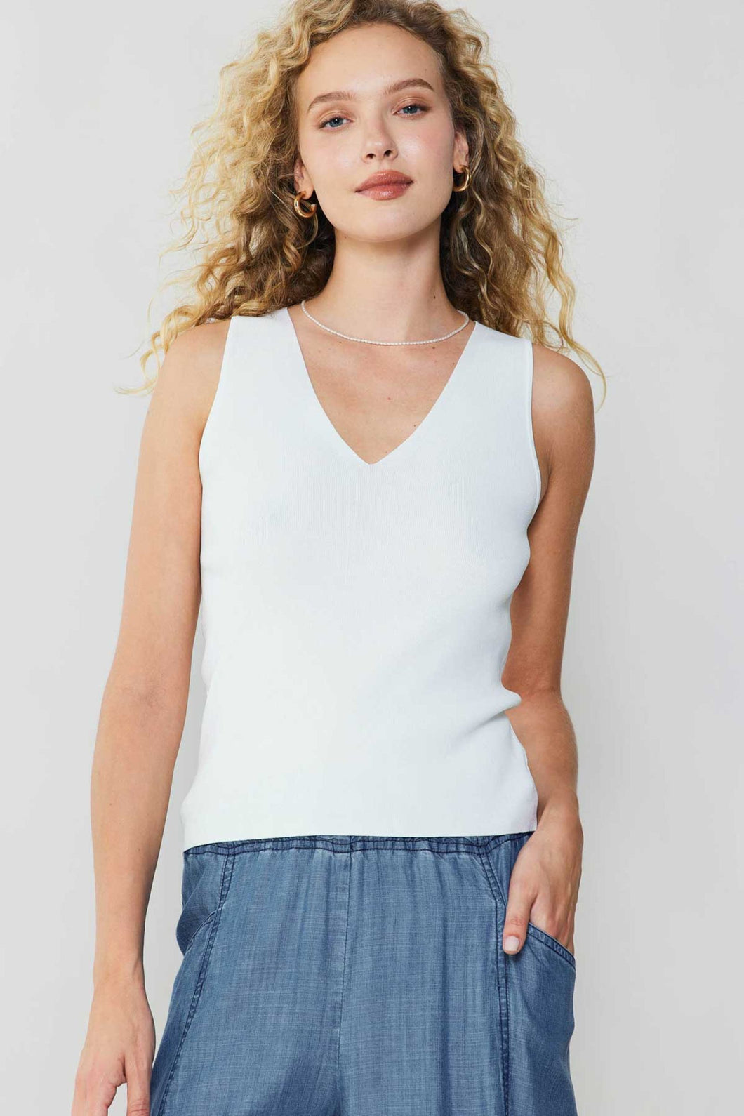 Capture style and luxury with Current Air's Sleeveless V-neck Sweater Top in crisp white. This exclusive piece features a sleeveless design and a V-neckline, elevating any outfit with elegance.