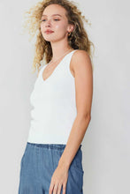 Load image into Gallery viewer, Achieve a fashionable and refined appearance with our Sleeveless V-neck Sweater Top in white, as seen on a model wearing blue denim pants. This ensemble exudes sophistication and comfort.

