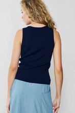 Load image into Gallery viewer, The back view of a woman in a blue skirt and navy blue top, highlighting a navy Sleeveless V-neck Sweater Top from Current Air for an elevated wardrobe.
