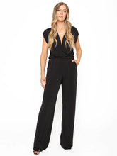Load image into Gallery viewer, Black Ripley Rader jumpsuit: Stretchy fabric, draped microfiber with elastic waist, deep pockets, gathered shoulders, plunging neckline option, laser-cut sleeves and hem, wrinkle-free.

