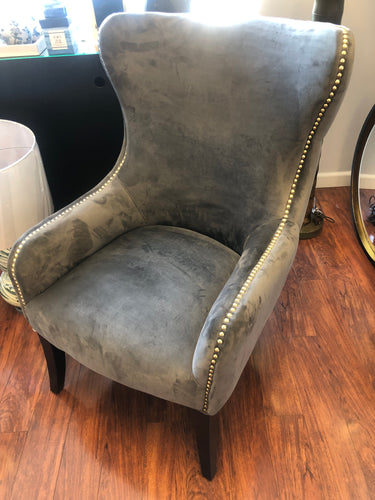 Grey suede chair with silver nailhead accents.