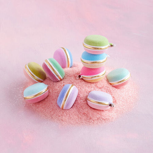 Whimsical rainbow macaron ornaments, hand-painted with gold leaf, adding elegance to holiday decor and perfect for gifts.