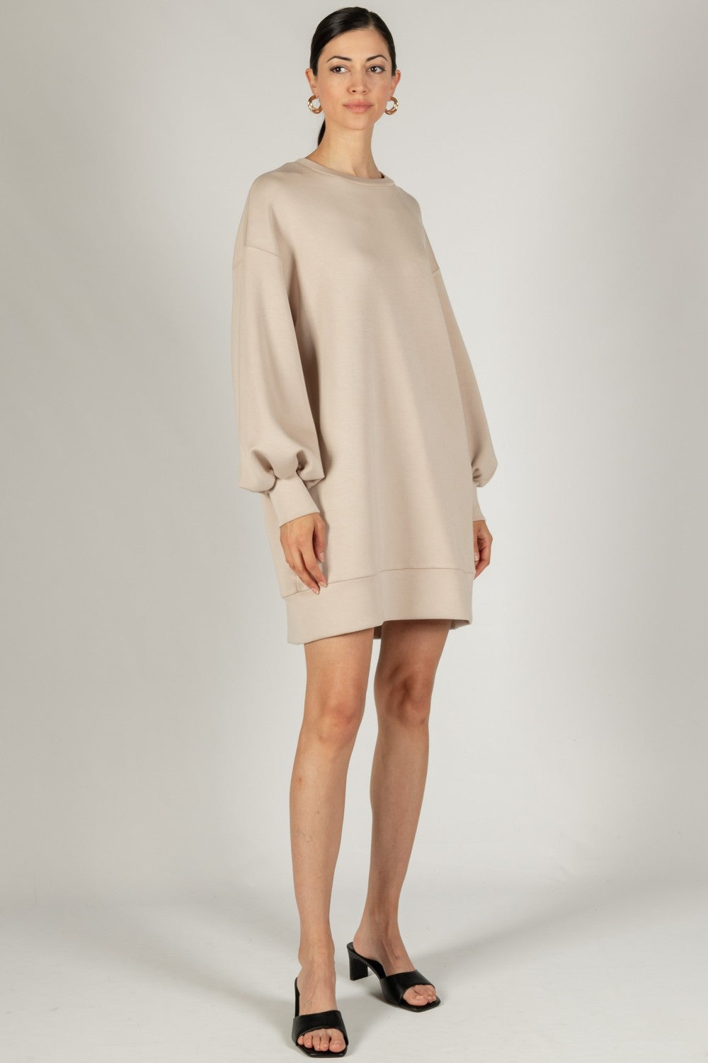 A taupe mini dress with dropped shoulders, long sleeves, and a round neck, crafted from durable scuba modal fabric.
