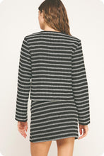 Load image into Gallery viewer, Woman wearing a black and white striped dress on a plain background
