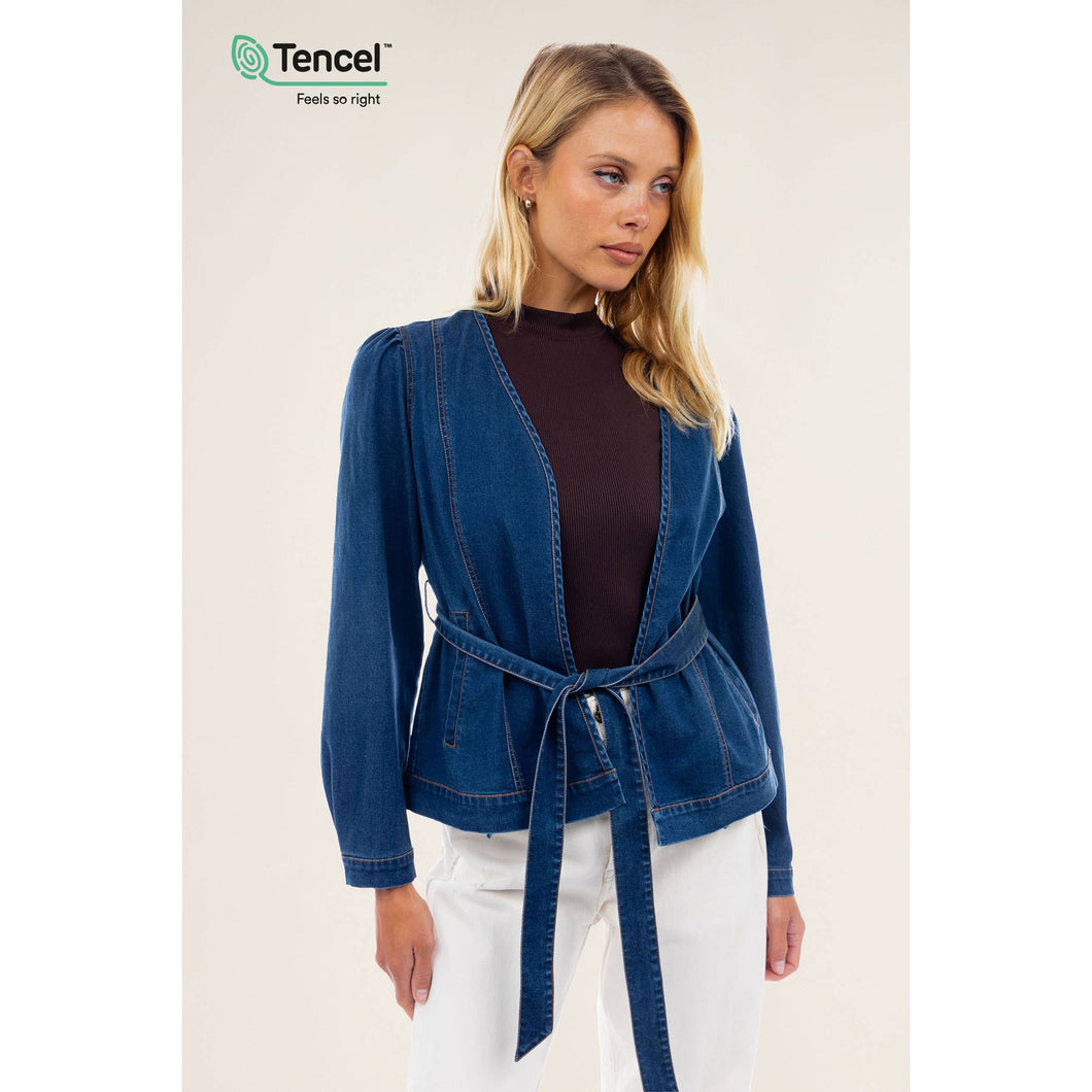 A blue denim wrap top with belt and white pants. Can be worn as a jacket or top. Belt adds a shaping factor making this piece elegant and versatile