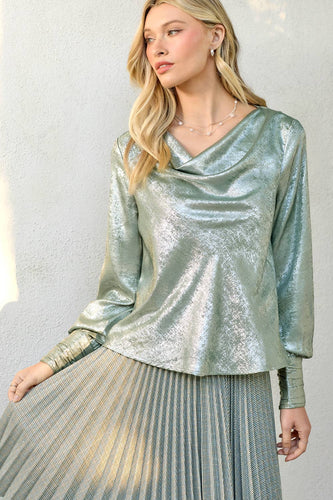 Woman wearing a silver metallic top and skirt against a neutral background