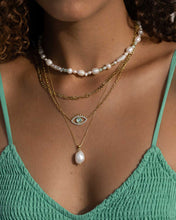 Load image into Gallery viewer, A fashion-forward woman wearing a vintage-inspired gold eye necklace.
