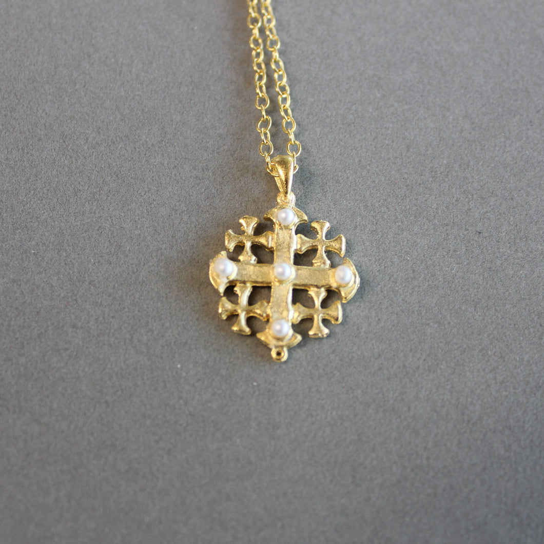 Gold cross necklace with pearl accents. 18